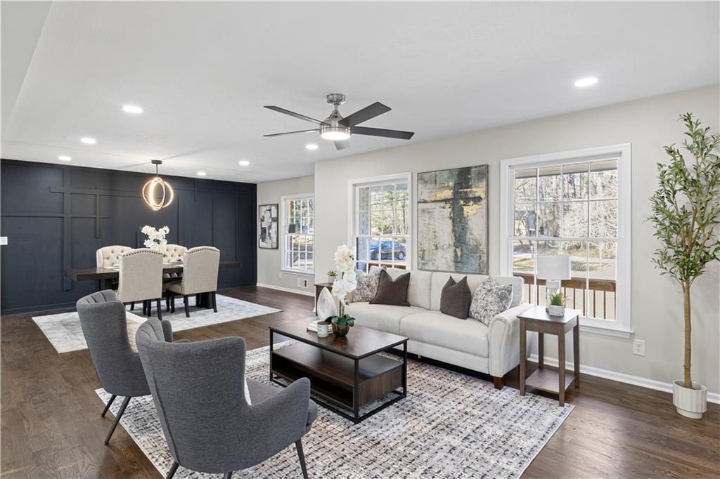 Staged living and dining room with a charcoal paneled accent wall
