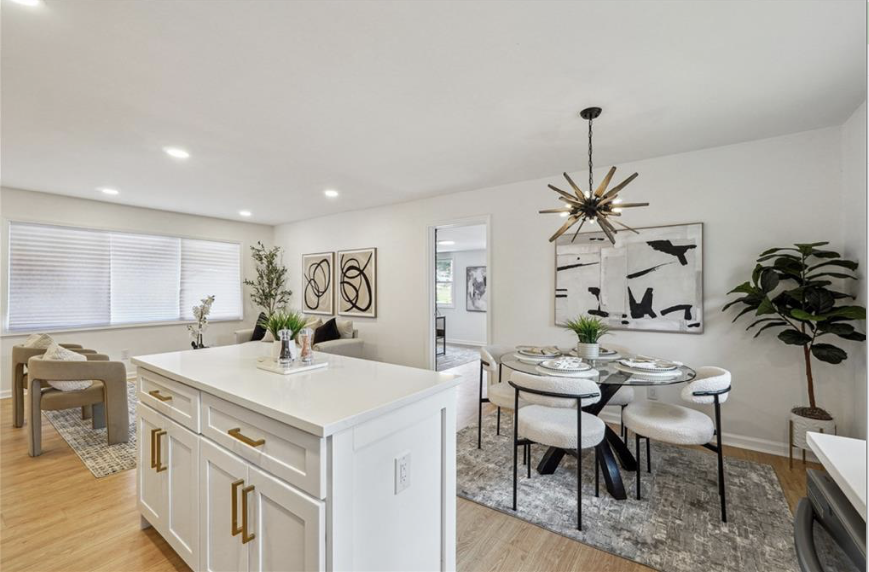 Staged open kitchen and dining room with brass details and modern artwork