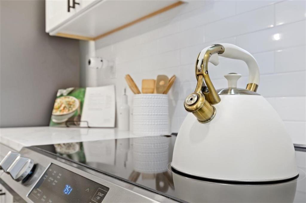 Styled kitchen detail with a white kettle and brass hardware