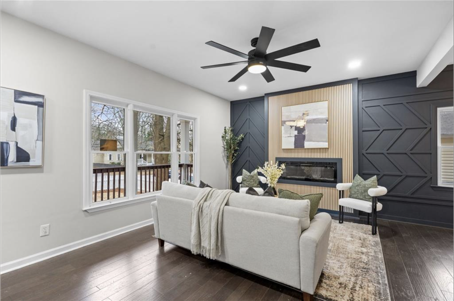Staged living room with a geometric charcoal fireplace wall